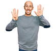 © Krakenimages.com - Bald man with beard wearing casual clothes showing and pointing up with fingers number nine while smiling confident and happy.