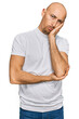 © Krakenimages.com - Bald man with beard wearing casual white t shirt thinking looking tired and bored with depression problems with crossed arms.