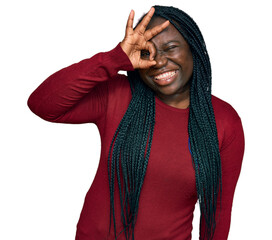 Canvas Print - Young black woman with braids wearing casual clothes smiling happy doing ok sign with hand on eye looking through fingers