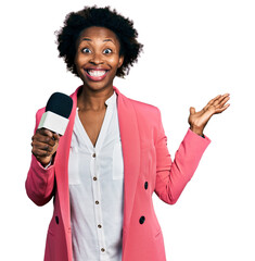 Canvas Print - African american woman with afro hair holding reporter microphone celebrating victory with happy smile and winner expression with raised hands