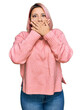 © Krakenimages.com - Hispanic woman with pink hair wearing casual winter sweater shocked covering mouth with hands for mistake. secret concept.