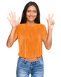 © Krakenimages.com - Young brunette arab woman wearing casual clothes showing and pointing up with fingers number eight while smiling confident and happy.