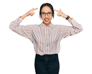 Wall Mural - Young hispanic girl wearing casual clothes and glasses smiling pointing to head with both hands finger, great idea or thought, good memory