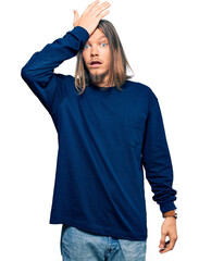 Poster - Handsome caucasian man with long hair wearing casual winter sweater surprised with hand on head for mistake, remember error. forgot, bad memory concept.