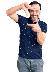 Poster - Middle age handsome man wearing casual polo smiling making frame with hands and fingers with happy face. creativity and photography concept.