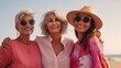 © Muzamil - a photo of three diverse middle-aged mature women in modern stylish clothes smiling, on a vacation at the seaside or beach, mature friendship representation.