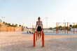 © ADDICTIVE STOCK - Young woman exercising at an outdoor park gym