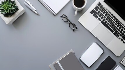 Top view of office essentials including a notepad laptop coffee cup mouse pad and mobile phone with a blank screen Copy space available on the desk workspace