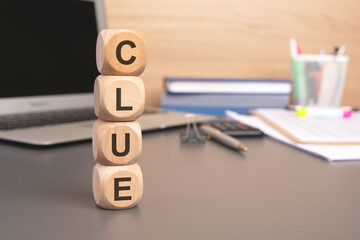 Poster - the word CLUE written on wooden cubes against computer keyboard background