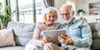 © hobonski - A heartwarming scene captures the essence of modern aging, as an elderly couple shares a moment of joy while exploring the digital world together on a tablet.