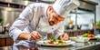 © Man888 - Professional chef garnishing gourmet dish in commercial kitchen