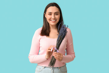 Poster - Beautiful happy young woman with bouquet of lavender flowers on blue background