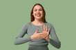 © Pixel-Shot - Young deaf mute woman using sign language on green background