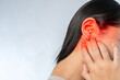 © jittawit.21 - Young woman suffering from ear pain and tinnitus. Cause of earache includes otitis, earwax buildup.
