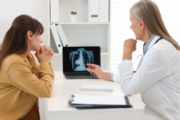 Sticker - Lung cancer. Doctor showing chest x-ray on laptop to her patient in clinic