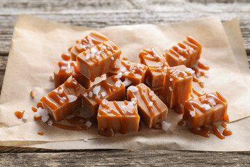 Wall Mural - Yummy candies with caramel sauce and sea salt on wooden table