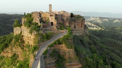 Wall Mural - Aerial summer evening view of famous Civita di Bagnoregio town, beautiful place located on top of a volcanic tuff hill overlooking the Tiber river valley. The place has Etruscan and Medieval origins.