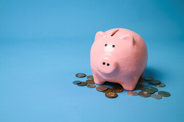 Pink Piggy Bank Smiling And Coins On The Blue Background