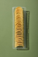 Wall Mural - Potato chips in a plastic tray on a green background