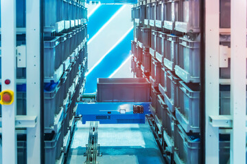 plastic boxes in the cells of the automated warehouse. Metal construction warehouse shelving