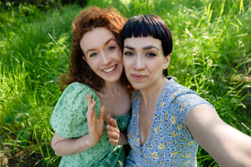 Two Women Pose for Selfie in Green Grassy Park