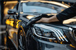 © btiger - Man cleaning black luxury car with microfiber cloth, close-up detailing, high quality photo