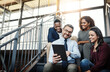 © StarDweller/peopleimages.com - Tablet, team and business people planning, research or brainstorming ideas for project on stairs. Digital technology, diversity and group of happy workers with engagement manager at startup meeting