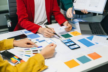 Wall Mural - close up view of ui developer team brainstorming on their project with laptop, smartphone and digita