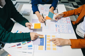 Wall Mural - close up view of ui developer team brainstorming on their project with laptop, smartphone and digita