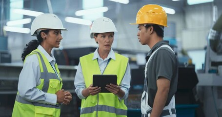 Leinwandbilder - Male and a Female Factory Employees Talk at a High Tech Manufacturing Facility, Discuss Operations and Production Machinery. Diverse Employees Wear Safety Gear and Use a Tablet Computer