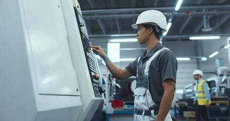 Leinwandbilder - Portrait of a Young Asian Male Technician in a White Hard Hat Setting Up an Automated CNC Milling Machine in an Advanced Manufacturing Plant. Metal Industry Specialist Performing Tasks at Work