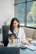 © laddawan - Young beautiful woman typing on tablet and laptop while sitting at the working white table