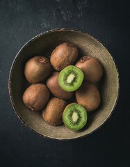 Wall Mural - kiwi in a bowl on a black background, top view, copy space 