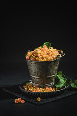 Wall Mural - white currants on a black plate and a metal bucket