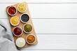 © New Africa - Many different sauces in bowls on white wooden table, top view. Space for text