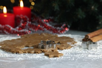 Wall Mural - Raw dough, cookie cutters, cinnamon and burning candles on grey marble table, closeup