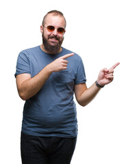 Sticker - Young caucasian hipster man wearing sunglasses over isolated background smiling and looking at the camera pointing with two hands and fingers to the side.