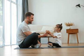 Sticker - Giving an apple. Father with little daughter are doing yoga at home