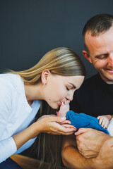 Wall Mural - Mom, dad and newborn son are playing at home. A happy family couple with a child.