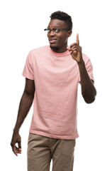 Wall Mural - Young african american man wearing pink t-shirt pointing finger up with successful idea. Exited and happy. Number one.