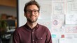 © Art Genie - Creative Male Product Manager Smiling at Camera in Casual Attire, Whiteboard with Product Ideas and Diagrams, Showcasing Innovation in Product Development and Business Strategy at the Office
