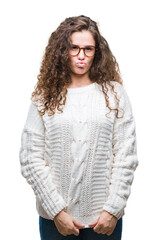 Sticker - Beautiful brunette curly hair young girl wearing winter sweater over isolated background puffing cheeks with funny face. Mouth inflated with air, crazy expression.