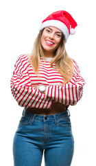 Canvas Print - Young beautiful woman wearing christmas hat over isolated background happy face smiling with crossed arms looking at the camera. Positive person.