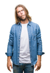 Canvas Print - Young handsome man with long hair over isolated background making fish face with lips, crazy and comical gesture. Funny expression.