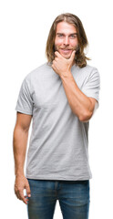 Canvas Print - Young handsome man with long hair over isolated background looking confident at the camera with smile with crossed arms and hand raised on chin. Thinking positive.