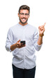 © Krakenimages.com - Young handsome man texting using smartphone over isolated background very happy pointing with hand and finger to the side