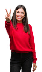 Sticker - Young beautiful hispanic wearing red sweater smiling looking to the camera showing fingers doing victory sign. Number two.