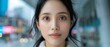 © MNFTs - A young woman with long black hair looks directly at the camera.