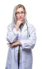 Sticker - Young blonde doctor woman over isolated background with hand on chin thinking about question, pensive expression. Smiling with thoughtful face. Doubt concept.