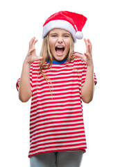 Wall Mural - Young beautiful girl wearing christmas hat over isolated background celebrating mad and crazy for success with arms raised and closed eyes screaming excited. Winner concept